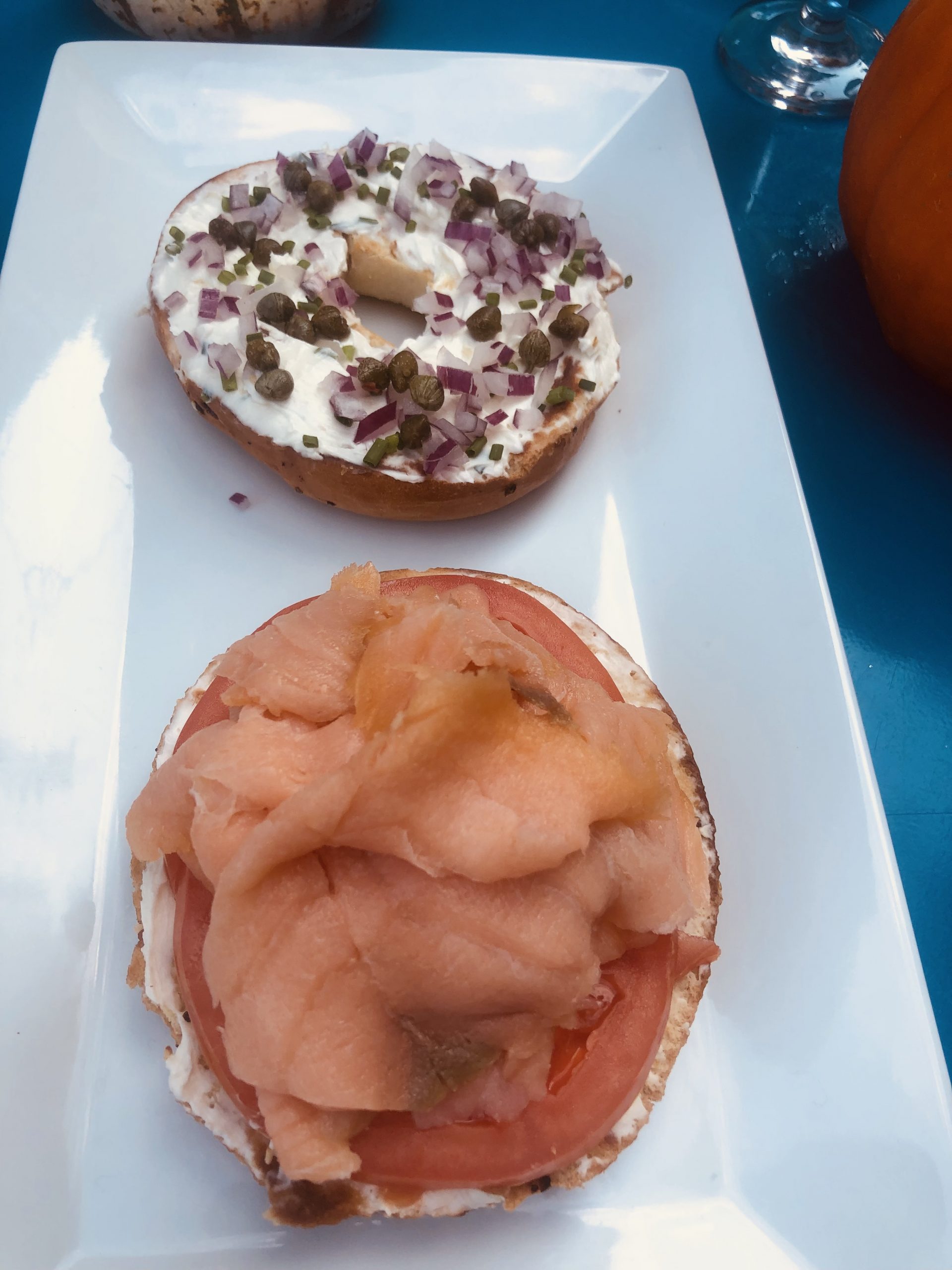 Two bagel sandwiches on a white plate.