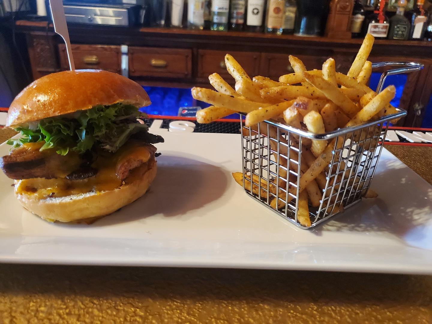 A burger and french fries on a plate.