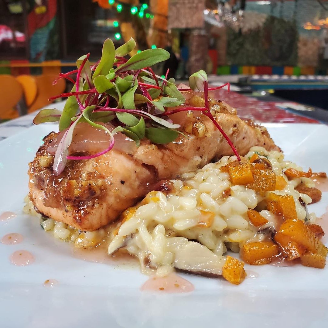 A plate with salmon and risotto on it.